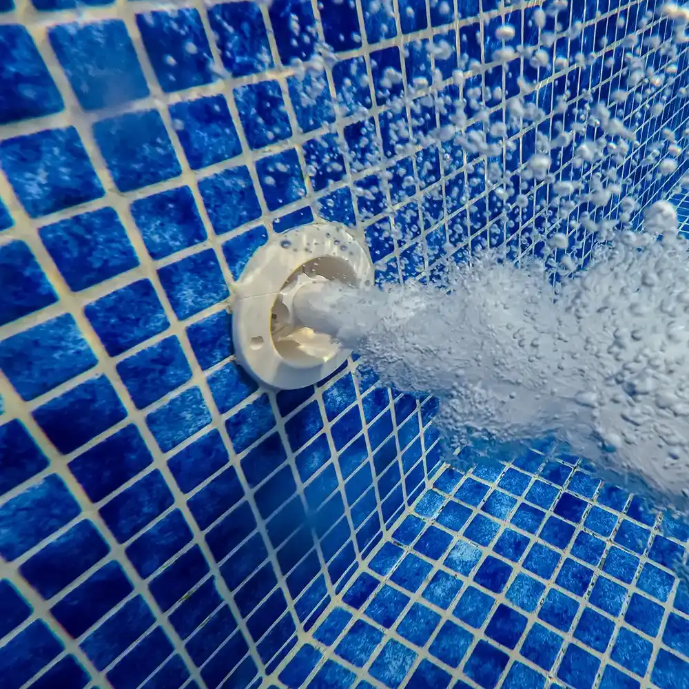 Unterwasseransicht der Mosaikfliesen und Wasserstrahlen des Pools