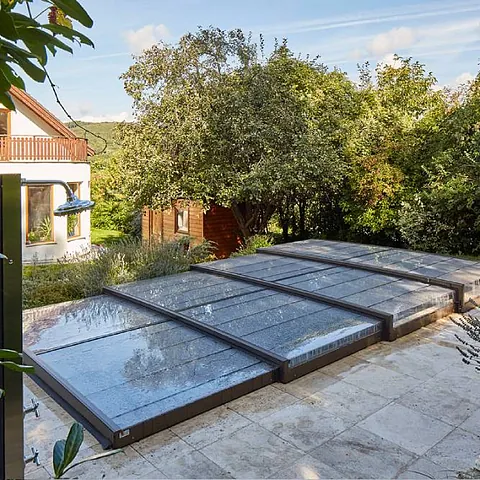 Faltbares Schwimmbaddach. Die Abdeckung aus Aluminium und Plexiglas läuft auf Schienen. Schützt das Schwimmbad vor Verschmutzungen aus der Umgebung, verhindert Wärmeverlust und hilft, die Sonnenwärme zu speichern.