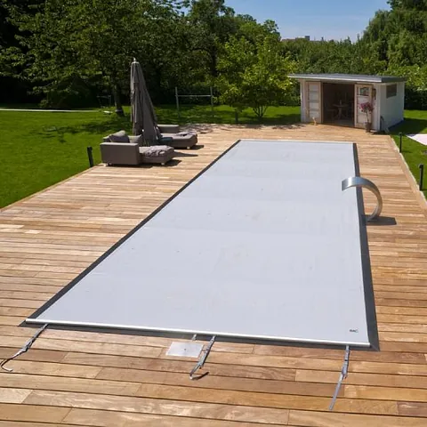 Schwimmbadabdeckung zum Schutz vor Schmutz, Laub, Heiz- und Kühlwasser, Kopierraum. Blaue Schwimmbadabdeckung aus Plane. Sommertag